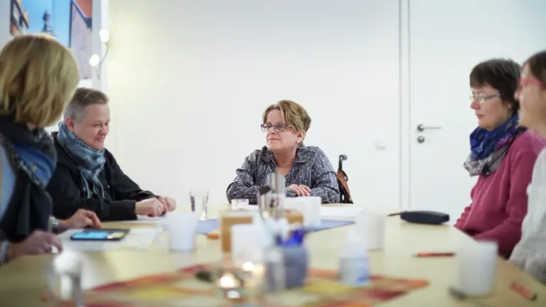 Mehrere Personen an einem Besprechungstisch.