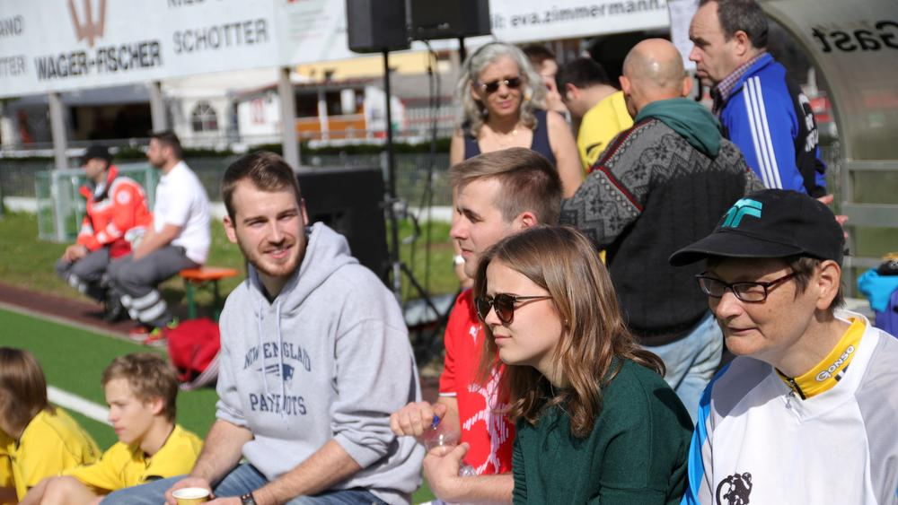 mehrere junge menschen sitzen im publikum, die sonne scheint