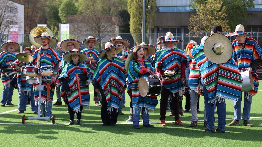 viele leute stehen auf dem fußballplatz und machen musik