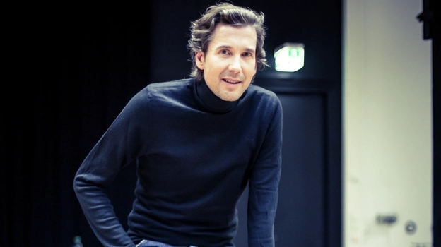 Marcus Brien sitzt auf einem Hocker