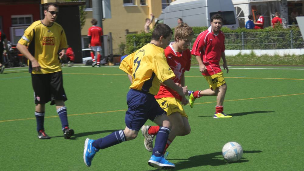 zwei jungs rennen auf dem spielfeld einem ball hinterher