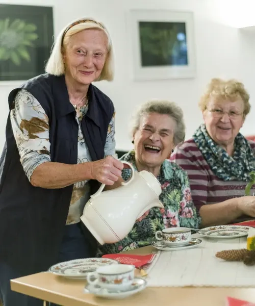 Drei ältere Frauen beim Kaffee trinken, sie lachen