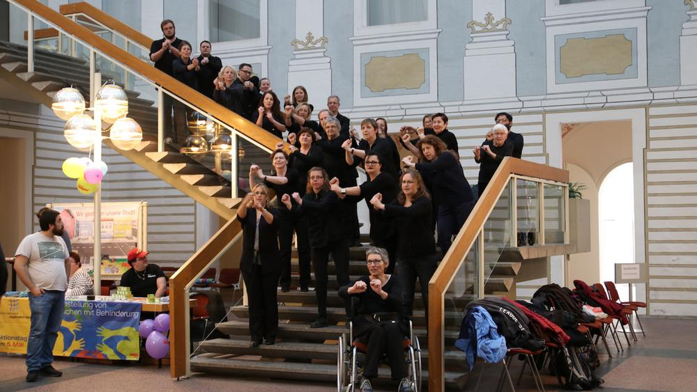 ein gehörlosen chor steht auf der treppe und singt