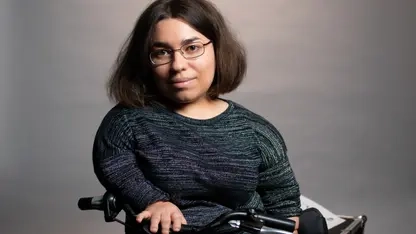 Porträt einer jungen, kleinwüchsigen Frau mit halblangen Haaren und Brille