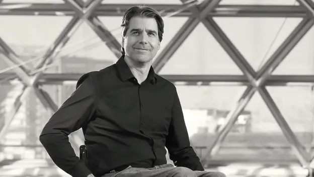 Ein Mann im Rollstuhl, der in die Kamera lächelt.