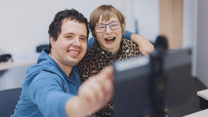 Ein junger Man und eine Frau nehmen zusammen ein Selfie auf.