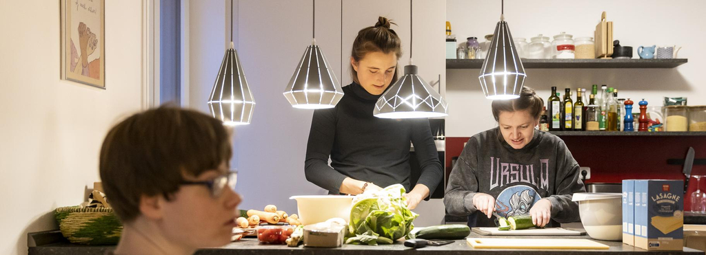 In einer Küche stehen zwei junge Frauen und bereiten Essen zu.
