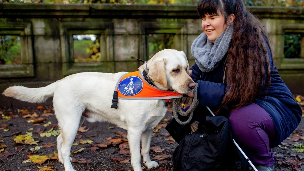 Carina kniet neben ihrem Blindenhund Pitou.