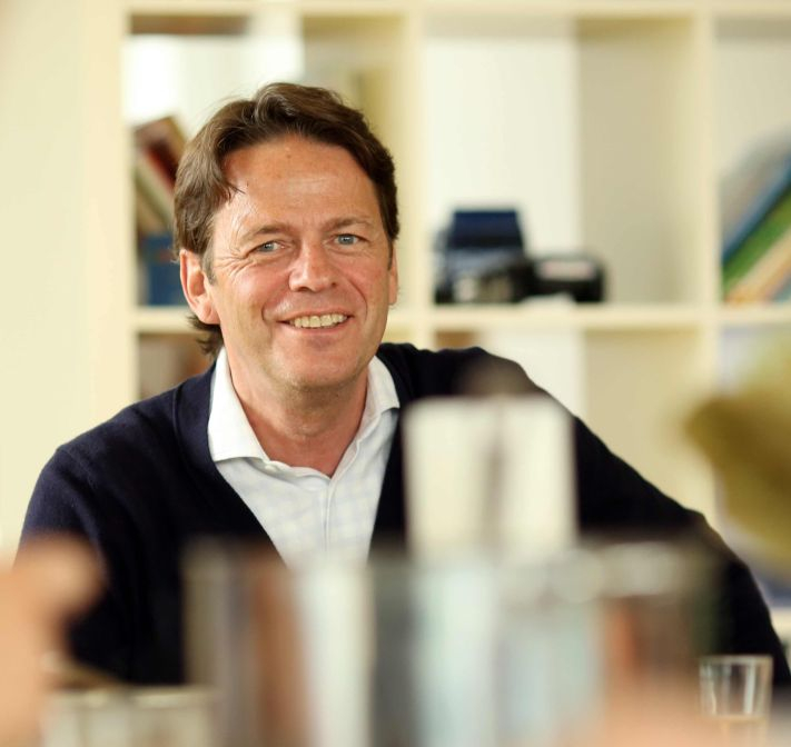 Rudi Cerne. Im Hintergrund sieht man ein Regal.