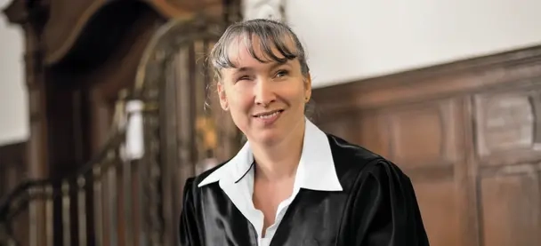 Blinde Juristin in Robe in einem Gerichtssaal