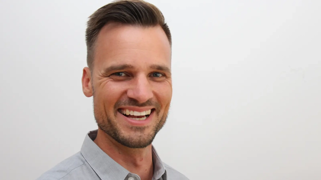 Porträt von Florian Walczak, Geschäftsführer der Access gGmbH. Das Bild zeigt einen Mann mit kurzem Bart, der in die Kamera lacht.