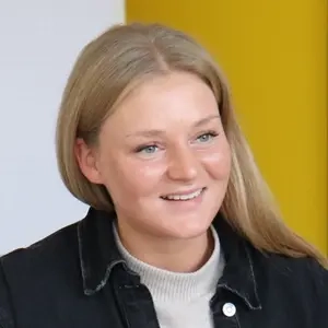 Selina Löw ist eine junge Frau mit langen blonden Haaren. Das Bild zeigt sie im Beratungsgespräch mit einer weiteren Person.