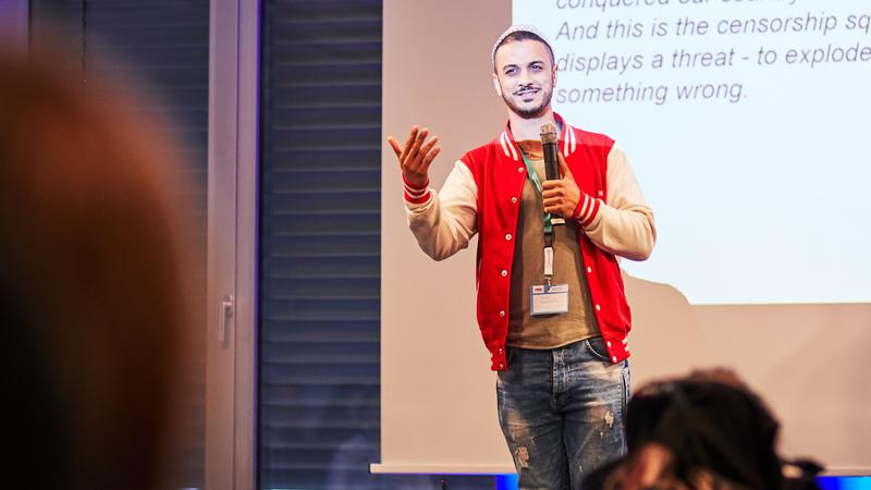 Der Moderator Younes auf der Bühne des Jugendaktionscamps.