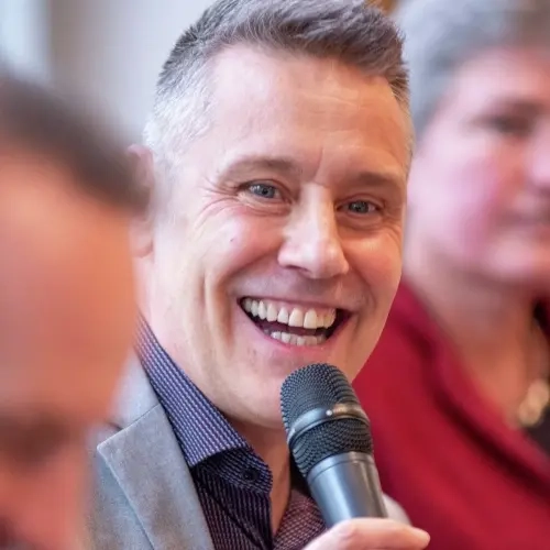Stefan Burkhardt mit einem Mikrofon lächelt