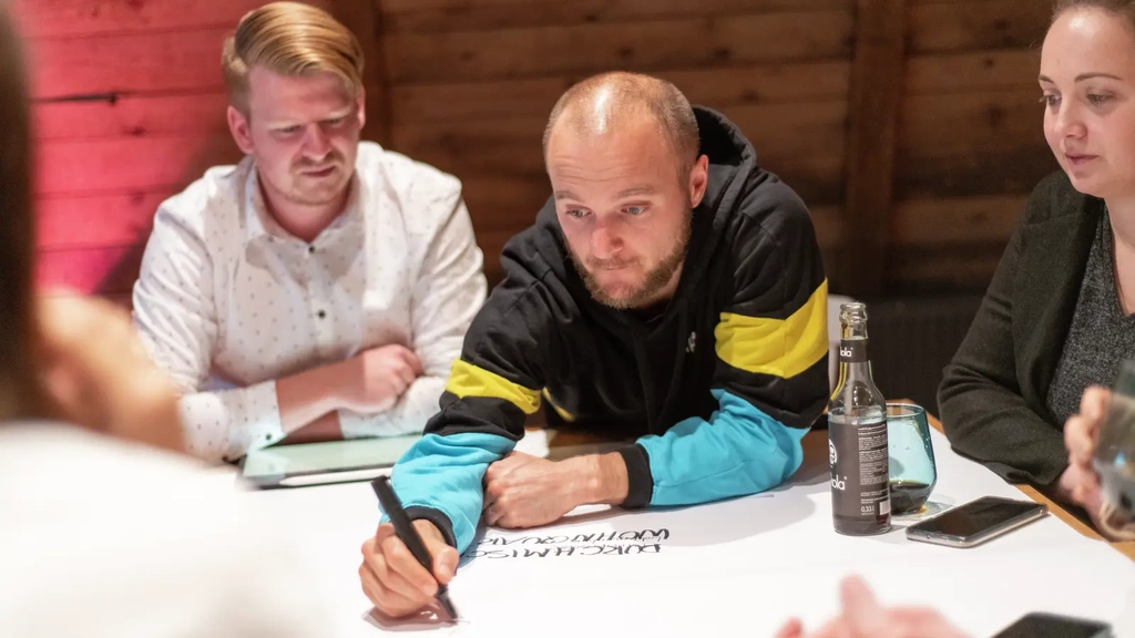 Ein Team arbeitet gemeinsam an einem Tisch zusammen