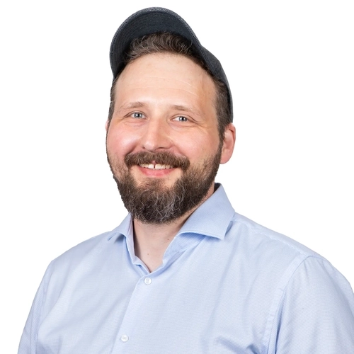 Porträt eines Mannes im blauen Hemd und Basecap.