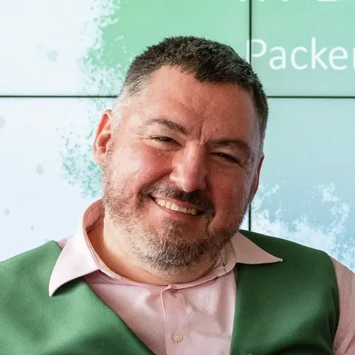 Ein Mann mittleren Alters mit kurzen grau melierten Haaren und kurzem Vollbart