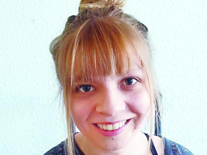 Eine lächelnde junge Frau mit blondem Pony