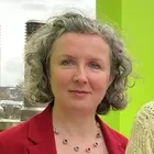 Drei Frauen stehen nebeneinander und schauen lächelnd in die Kamera.