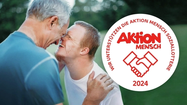 Ein Mann und ein Jugendlicher haben ihre Gesichter sehr dicht beieinander und lachen sich an. Daneben ist das Aktion Mensch-Siegel abgebildet.