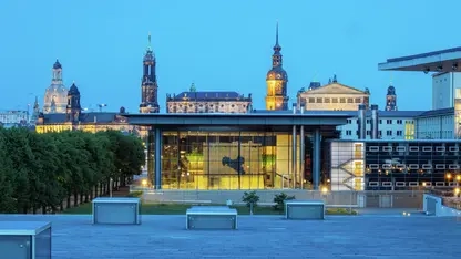 Abendlicher Blick von außen über den innen erleuchteten sächsischen Landtag hinweg auf die Wahrzeichen der Dresdener Altstatdt mit den Dächern der Frauenkirche, Semperoper und Gemäldegalerie