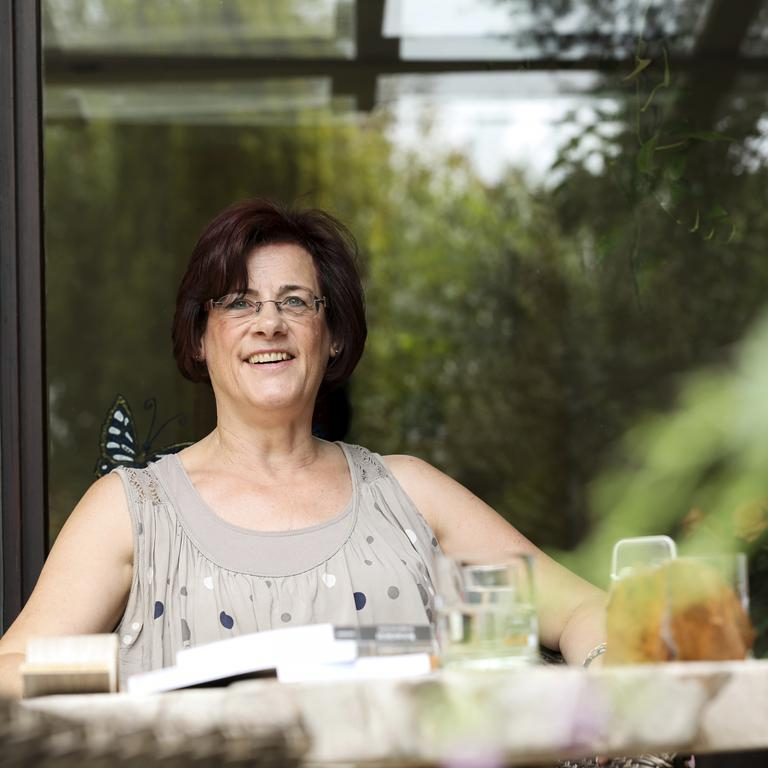 Die Aktion Mensch Lotto-Gewinnerin Gabi aus Baesweiler auf ihrer Terrasse.