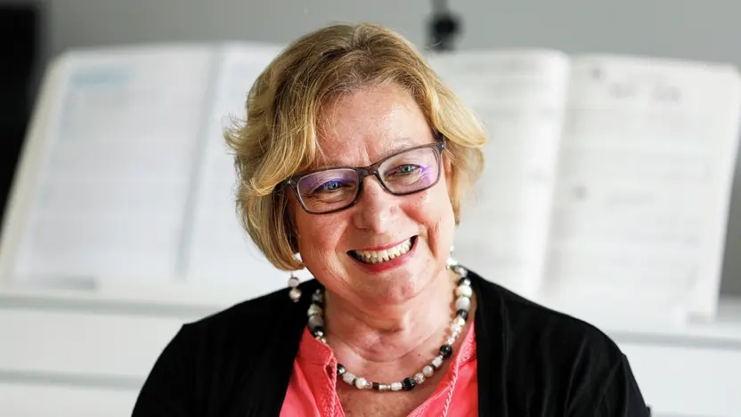 Die Aktion Mensch Lotterie-Gewinnerin Regina sitzt in ihrem Wohnzimmer und erzählt von ihrem Gewinn.