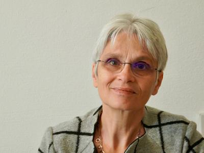 Portrait einer Frau mit kurzen grauen Haaren und Brillen