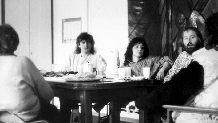 Vier Personen sitzen an einem Besprechungstisch 