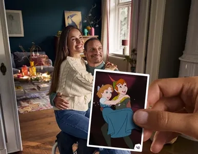 Eine Frau sitzt auf dem Schoß ihres Mannes, der im Rollstuhl sitzt. Beide lachen. Im Vordergrund hält eine Hand einen Disney-Sticker, der ein ähnliches Motiv mit Peter Pan und Wendy.