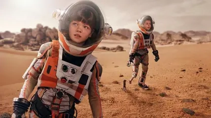 Zwei Kinder in Astronautenanzügen auf dem Mars. Ein Kind hat eine Beinprothese.