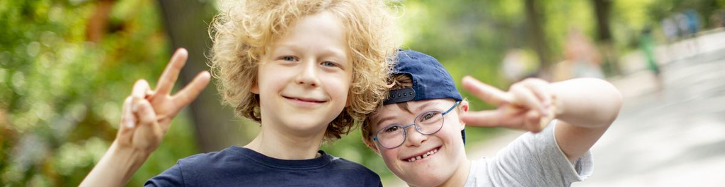 Zwei Jungs, Leopold und Thibaud, stehen lachend nebeneinander und zeigen das Victory-Zeichen in die Kamera.