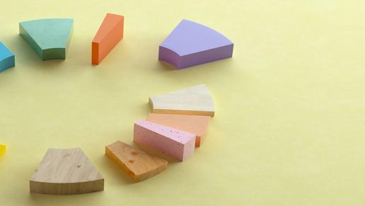 Bunte Bauklötze in einem Kreis bilden ein Kuchendiagramm nach.