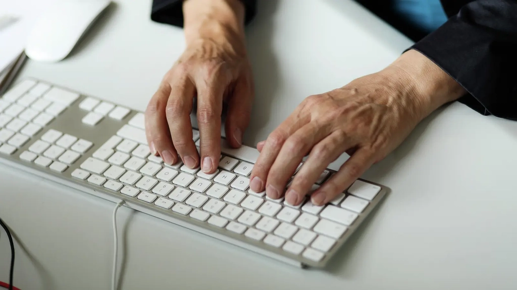 Zwei Hände liegen auf einer Computertastatur und tippen.