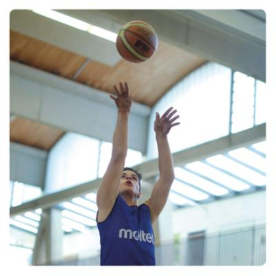 Eine Karte des InkluMemo-Spiels: darauf die obere Körperhälfte eines Basketballspielers, der gerade den Ball wirft.