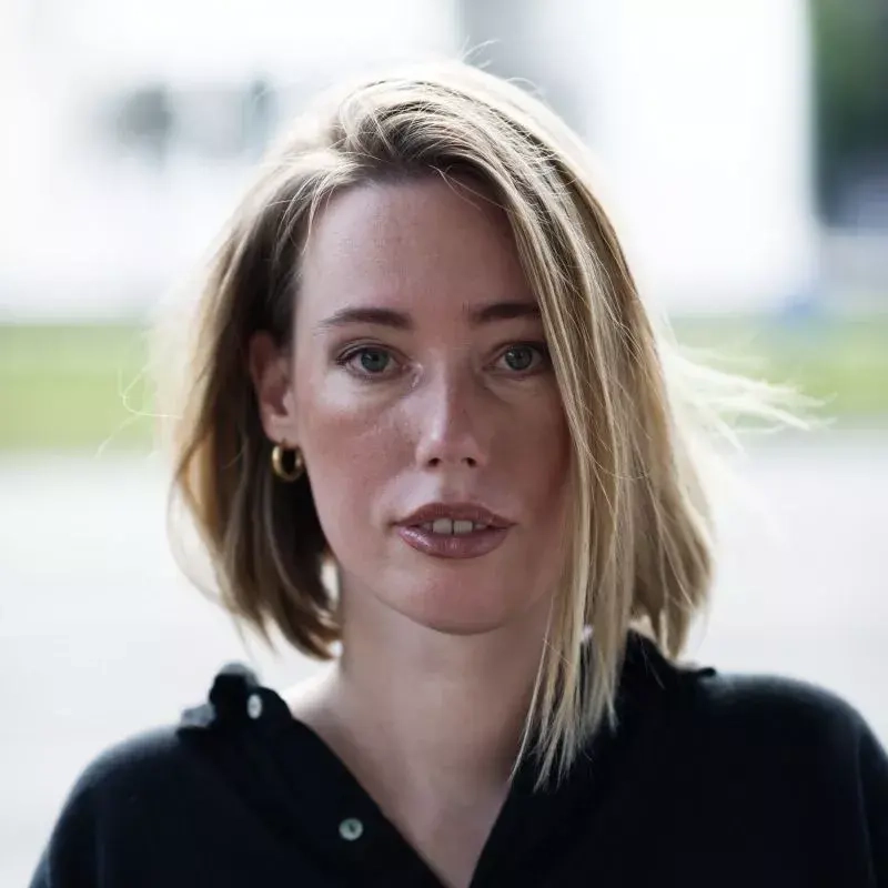 Ein Porträtfoto einer jungen Frau mit blondem, mittellangem Haar.