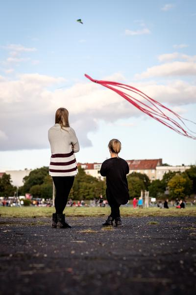 Nicole und Jacqueline von hinten zu sehen, sie schauen einem fliegenden Drachen zu.