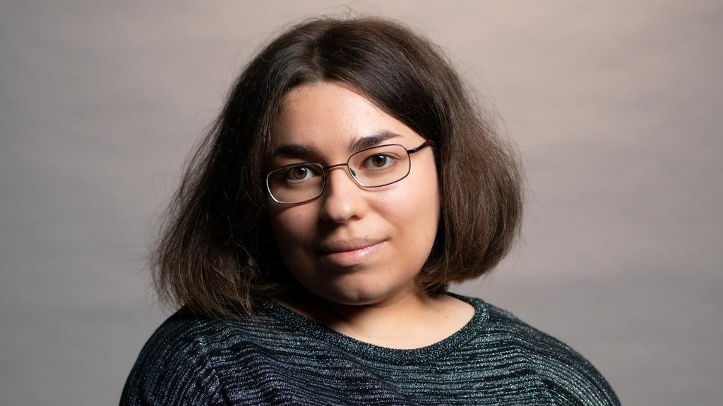 Porträt einer jungen, kleinwüchsigen Frau mit halblangen Haaren und Brille