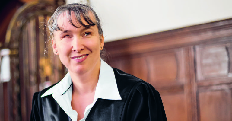 Blinde Juristin in Robe in einem Gerichtssaal