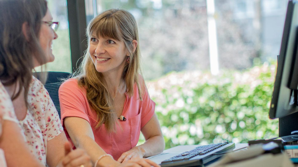 Zwei Frauen sitzen gemeinsam am PC.