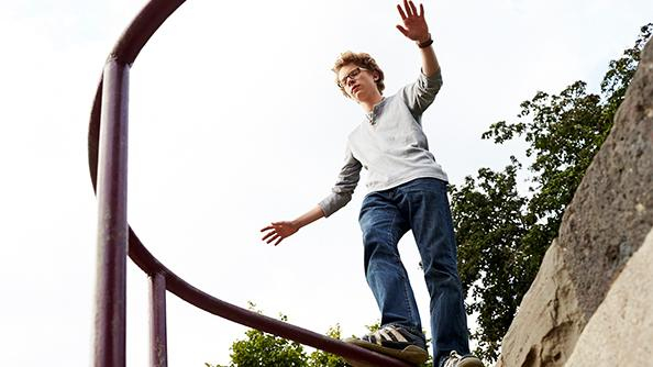 Junge balanciert auf Geländer