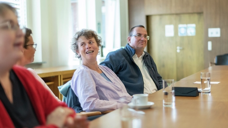 Mehrere Menschen sitzen im Ratssaal von Schneverdingen und unterhalten sich.