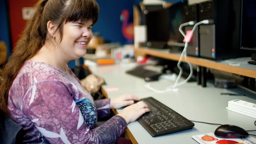Carina sitzt im Computerraum und tippt an einer Tastatur.