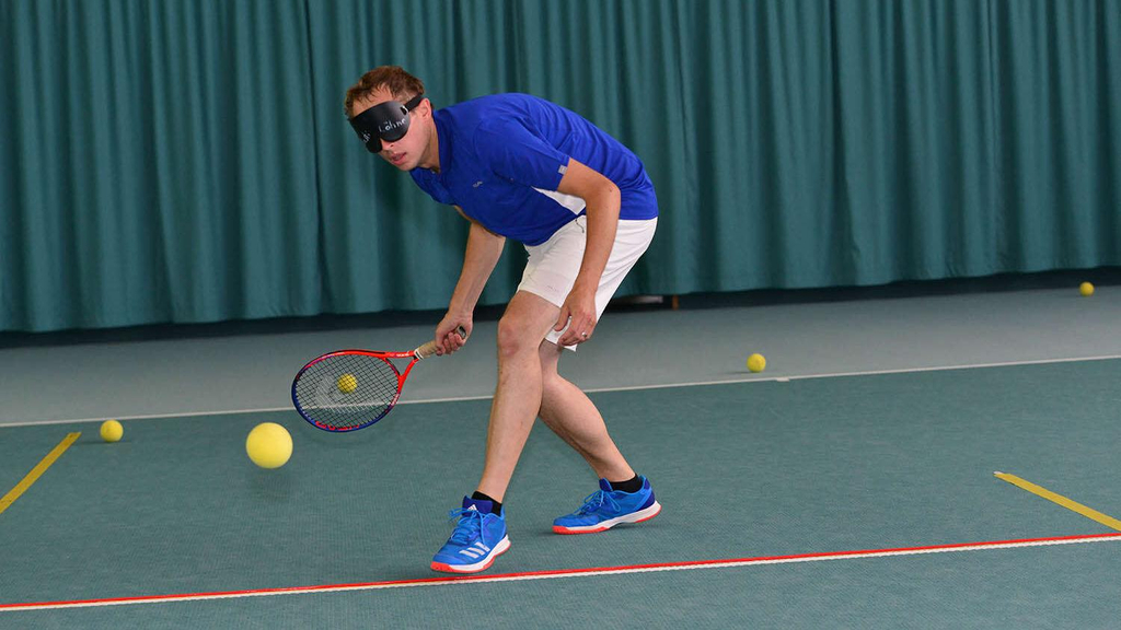Spieler spielt Blindentennis in der Halle