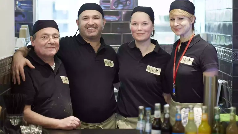 Das Team des Restaurant "Godesburger" steht hinter der Theke