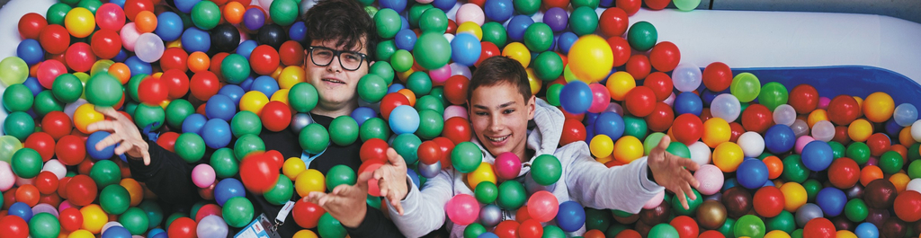 Zwei Jugendliche in einem Bällebad.