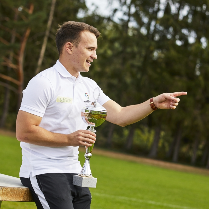 Projektmacher Maurice mit dem Pokal in der Hand.