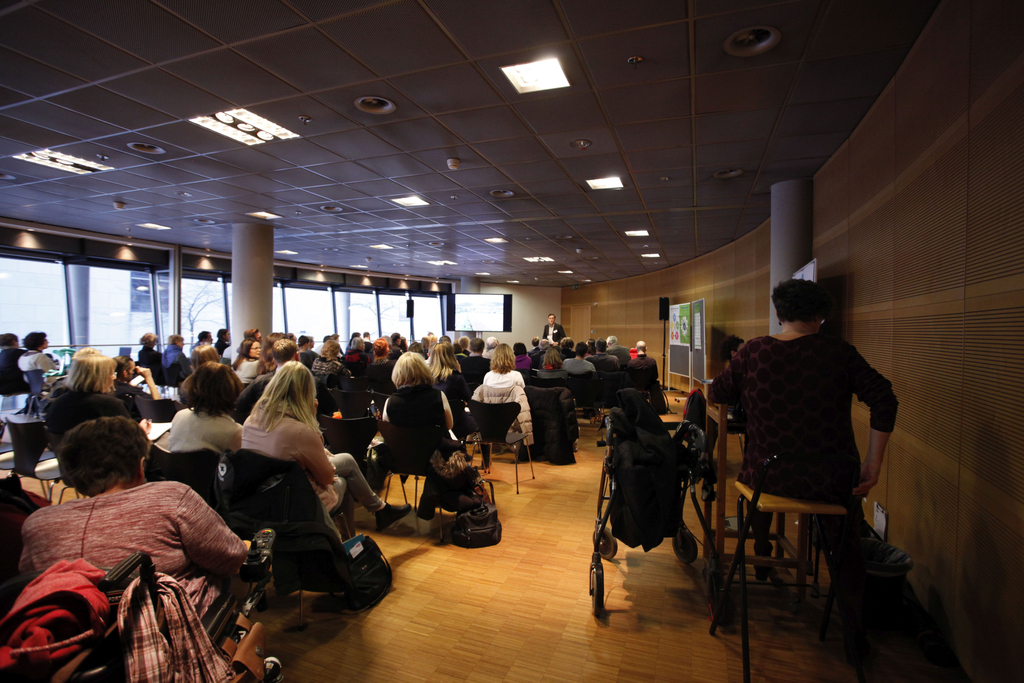 Rückansicht der Teilnehmer. Sie hören dem Beitrag von Dr. Tobias Federwisch zu. 