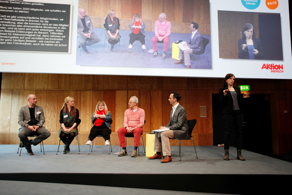 Der Moderator Frank Liffers sitzt mit seinen Gästen auf der Bühne.