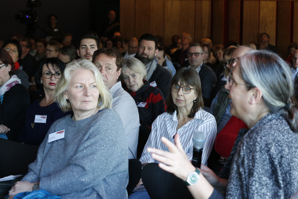 Eine Frau im Publikum spricht in das Handmikrofon